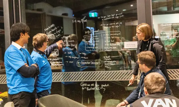 Workshop participants brainstorm their ideas using a window as a whiteboard